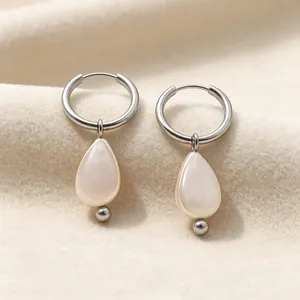 Vue détaillée de boucles d'oreilles pendantes en perle de nacre et acier titane