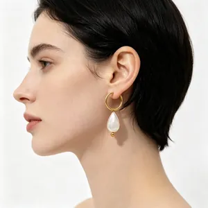 Vue macro détaillée d'une boucle d'oreille goutte en perle portée par un mannequin.