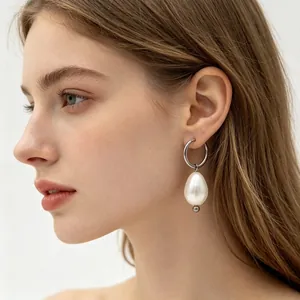 Vue détaillée d'un modèle portant des créoles de style français avec perle de nacre.
