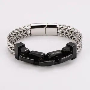 Détail macro d'un bracelet homme en acier inoxydable avec chaîne argentée et maillons noirs