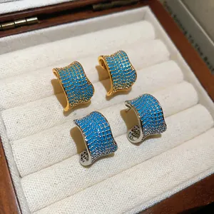 Primo piano di orecchini a C retrò con pietre blu in finitura oro e argento