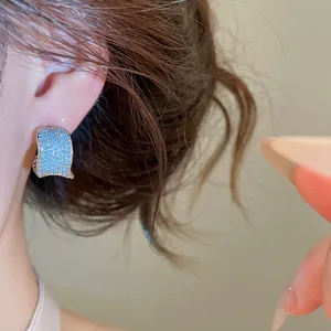 Dettaglio di un orecchino a C vintage placcato oro con pavé di zirconi turchesi