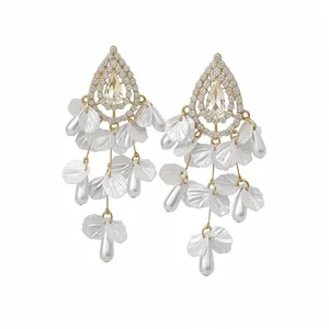Pendientes vintage elegantes con perlas, pétalos de concha y cristalli sobre fondo blanco