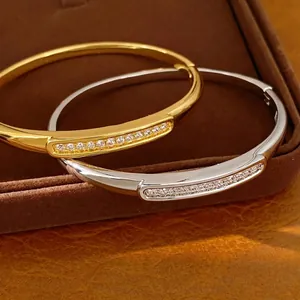 Premium 18K gold-plated oval bangles with shimmering zircon accents on jewelry box