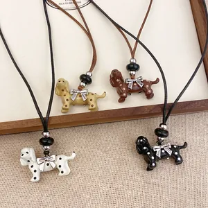 Close-up detail of four colorful polka dot dog necklaces featuring delicate bow accents