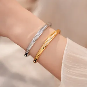 Detailed view of gold and silver bangles with sparkling zircon inlay on a wrist.