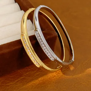 Detailed view of 18K gold plated and silver oval bangles featuring pavé zirconia stones