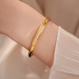 Close-up of elegant 18K gold-plated oval bangle with sparkling zircon stone inlay