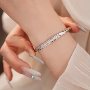 Close-up of 18K gold plated silver bangle with sparkling zircon inlay on model's wrist