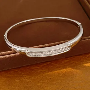 Detailed view of a silver oval bangle bracelet with shimmering zircon stone inlay.