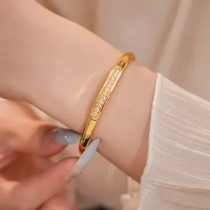 Detail shot of elegant 18K gold-plated oval bangle with a row of clear sparkling zircons