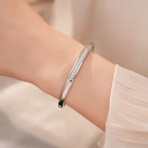 Close-up view of an elegant 18K gold plated oval bangle set with sparkling clear zircons