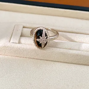 Nahaufnahme eines silbernen Vintage-Rings mit Tigerauge und einem Zirkonia-Stern-Detail