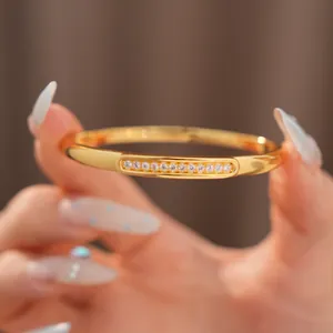 Detailed macro view of sparkling zircon inlay on the 18K gold-plated oval bangle bracelet