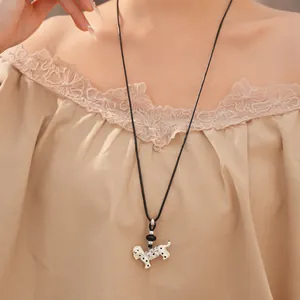 Detail showing a Dalmatian dog pendant on a black cord long necklace