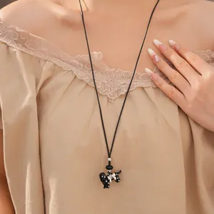 Elegant black dog pendant necklace with white polka dots and bow on long leather cord