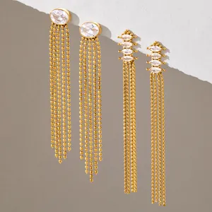 Gros plan de boucles d'oreilles à franges en acier doré avec pierres de zircon