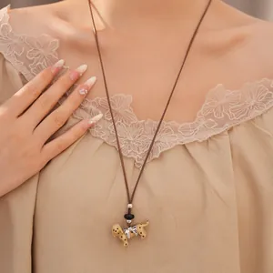 Minimalist spotted dog pendant necklace on brown leather cord with silver bow tie detail