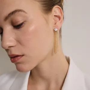Vue rapprochée de boucles d'oreilles à pampilles en acier doré avec zircon ovale