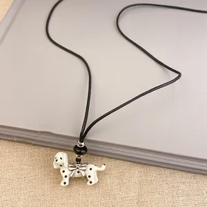 Detailed view of fashionable dalmatian dog pendant necklace with black cord and silver bow
