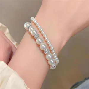 Nahaufnahme des eleganten zweireihigen Perlenarmbands mit funkelnden Strass-Elementen