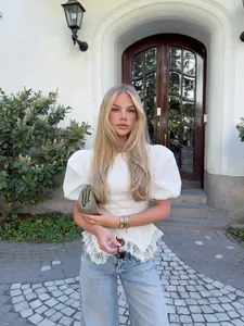 Elegante witte blouse met pofmouwen en delicate kanten zoom in een modieuze pasvorm.
