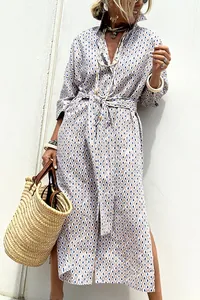 Full-length geometric print shirt dress with tie waist and straw tote bag styling.
