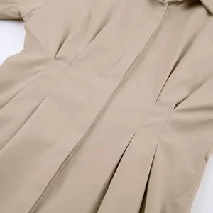 Gedetailleerde close-up van de geplooide taille van een kaki Franse stijl overhemdjurk.