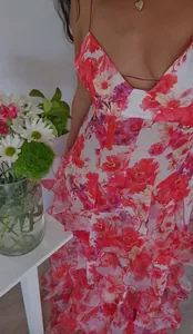 Close-up of floral organza tiered ruffles on a pink and orange evening maxi dress