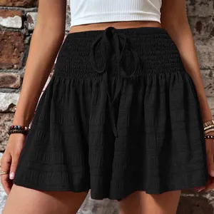 Detailed view of black high-waisted drawstring shorts with textured fabric style.