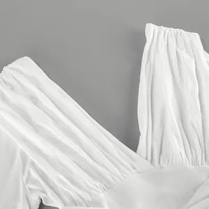 Detalle de primer plano de un top de modal blanco con cuello en V y drapeado elegante