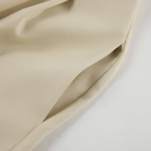 Detaillierte Nahaufnahme der Seitentasche und des feinen Plissee-Designs der khakifarbenen Hose