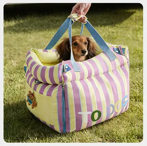 Siège auto rayé 2-en-1 pour animaux de compagnie, présenté à l'extérieur avec un petit chien