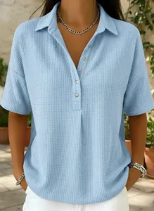 Gros plan sur la texture gaufrée bleu clair d'un polo à manches courtes pour femmes