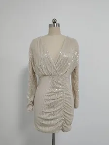 Detailed view of champagne sequin V-neck dress with elegant pleated texture and long sleeves.