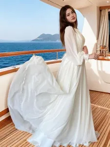 Elegante abito da sposa bianco con maniche a lanterna e filato perlato su uno yacht