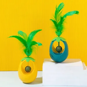Interactive pineapple shaped catnip tumbler toy with green feathers for dental health