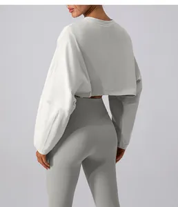 Back view of a cropped light grey crewneck sweatshirt and matching yoga leggings