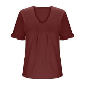 Detalle de la blusa granate de mujer con cuello en V, mangas con volantes y pliegues.