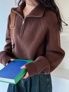 Dettaglio di un maglione marrone in maglia a coste con mezza zip e trama morbida
