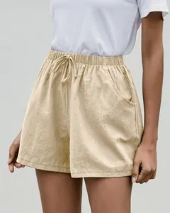 Vista detallada de pantalones cortos de lino beige con cintura elástica y bolsillos