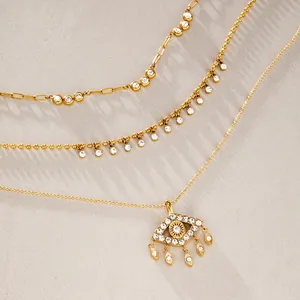 Vista macro del collar con colgante de ojo de buey dorado con borlas de circonitas