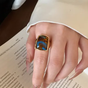 Κοντινό πλάνο vintage χρυσού δαχτυλιδιού από ατσάλι με ορθογώνια πέτρα μάτι της τίγρης