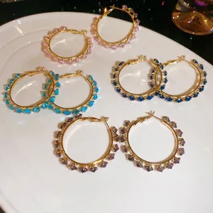 Elegant gold-tone hoop earrings decorated with sparkling multi-color zircon crystals