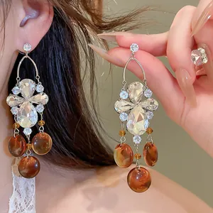 Gros plan de boucles d'oreilles vintage avec zircons et gouttes de résine ambrée