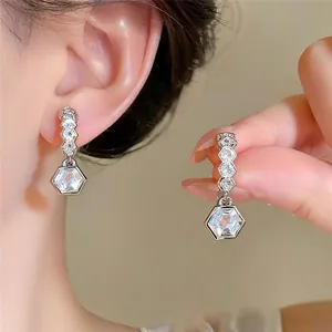 Detailansicht von silbernen Zirkonia-Ohrringen mit einem geometrischen Hexagonal-Kristall