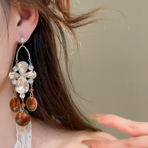 Gros plan de boucles d'oreilles vintage en cristal avec gouttes d'ambre sur un modèle