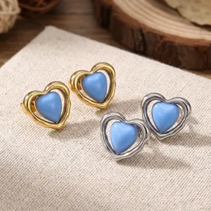 Primer plano detallado de pendientes de resina con forma de corazón azul y plata