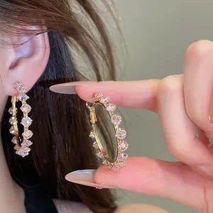 Detailed macro view of elegant gold hoop earrings with sparkling pink cubic zirconia