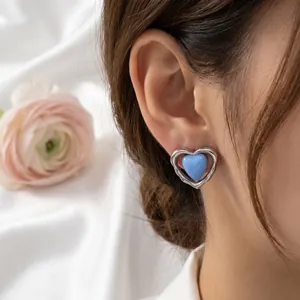 Primer plano de pendiente de corazón azul esmaltado con marco de acero inoxidable